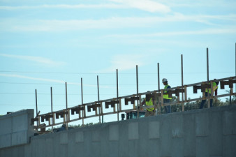 Workers build a wall on the north side of SR 56, east of I-75